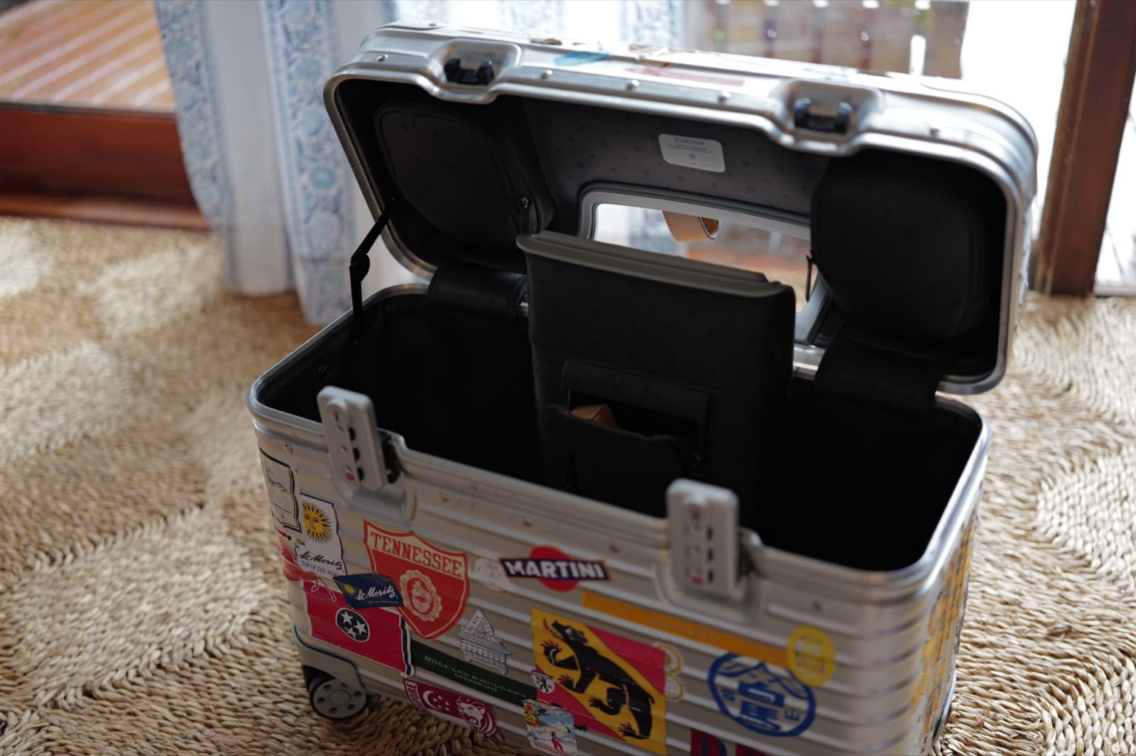 The Rimowa Pilot open, lid folded flat back on its struts, structured black interior and document pocket visible.